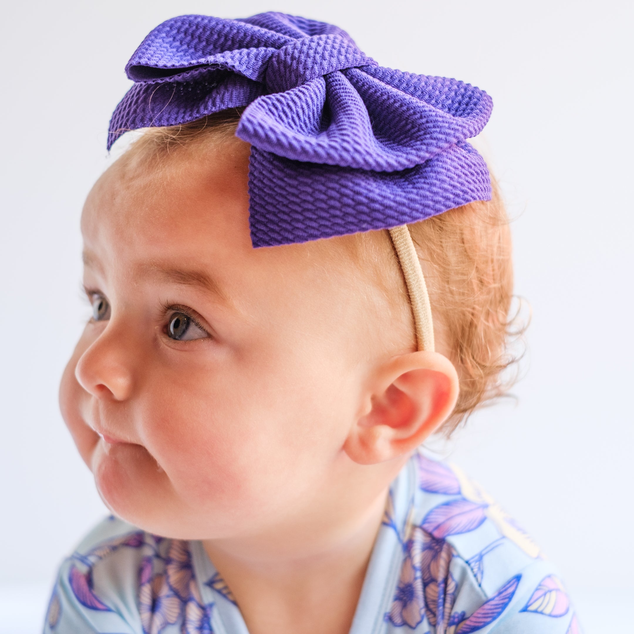 Purple big bow headband on baby. 