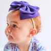 Purple big bow headband on baby. 